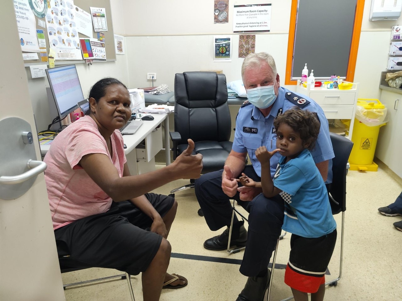 Gary Dreibergs with an Indigenous woman and a little boy in a vaccination room