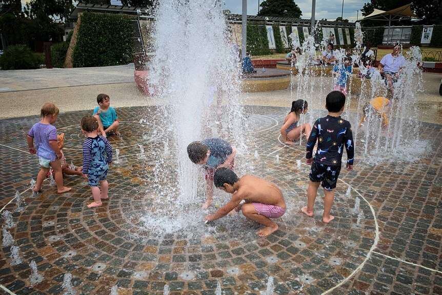 Children play at a water park on a sunny and warm day.