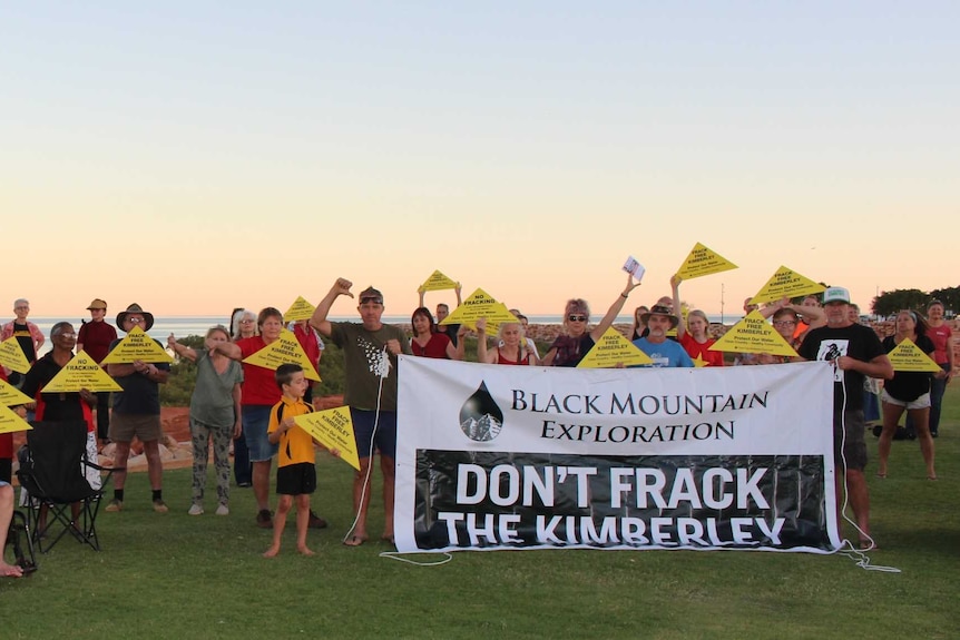 People hold banners opposing fracking.