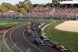 F1 cars come out of the first turn at the 2022 Australian Grand Prix