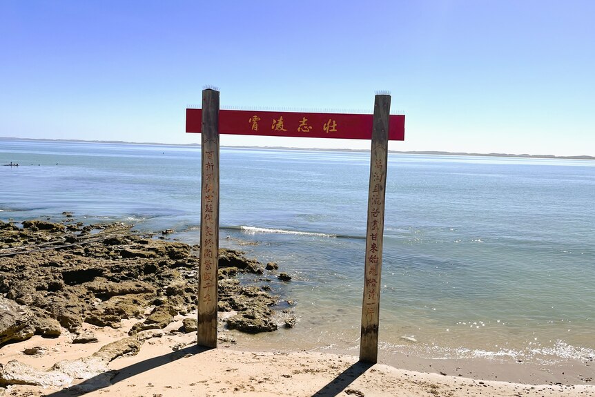 A red sign displaying Chinese characters on the beach at Robe, South Australia