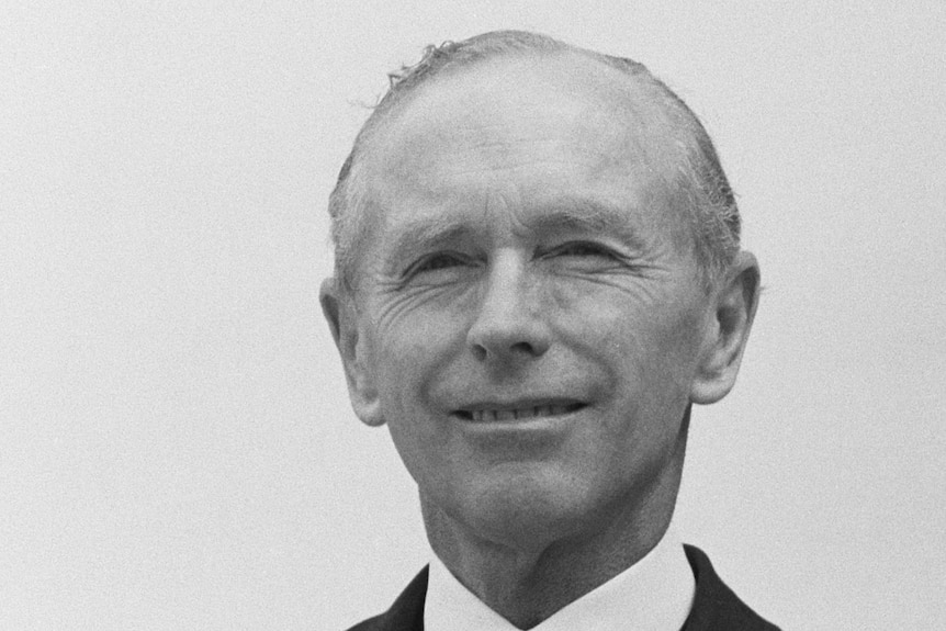 Alec Douglas-Home looks at the camera as he smiles for a portrait.