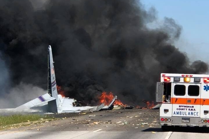 Wreckage of a plane, black smoke and an ambulance.