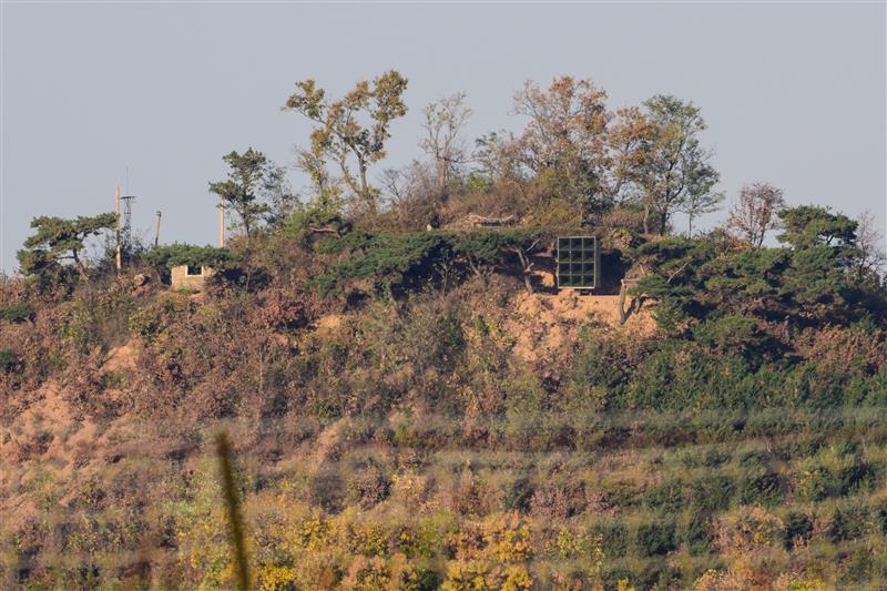 Large speakers on top of a hill. 