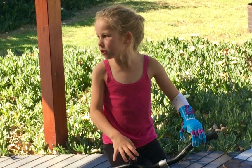 Lois Agnello riding a bike with her prosthetic hand