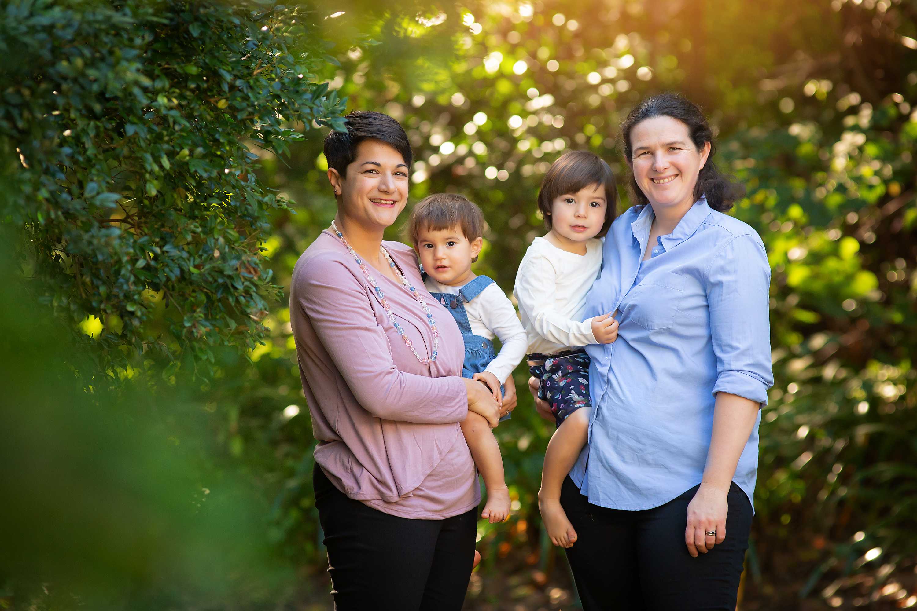 Two women holding their two kids.