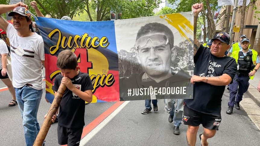 A march with a banner "Justice 4 Dougie".