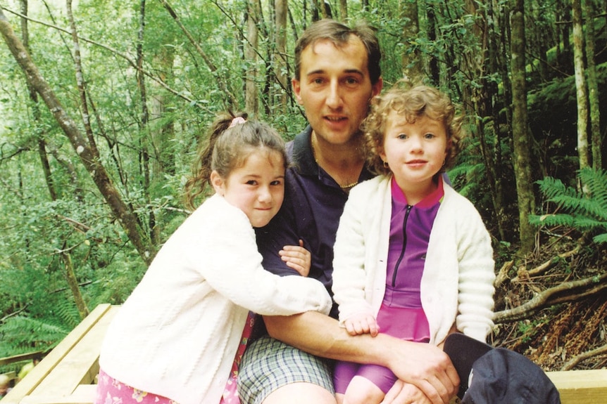 A man with two young girls.