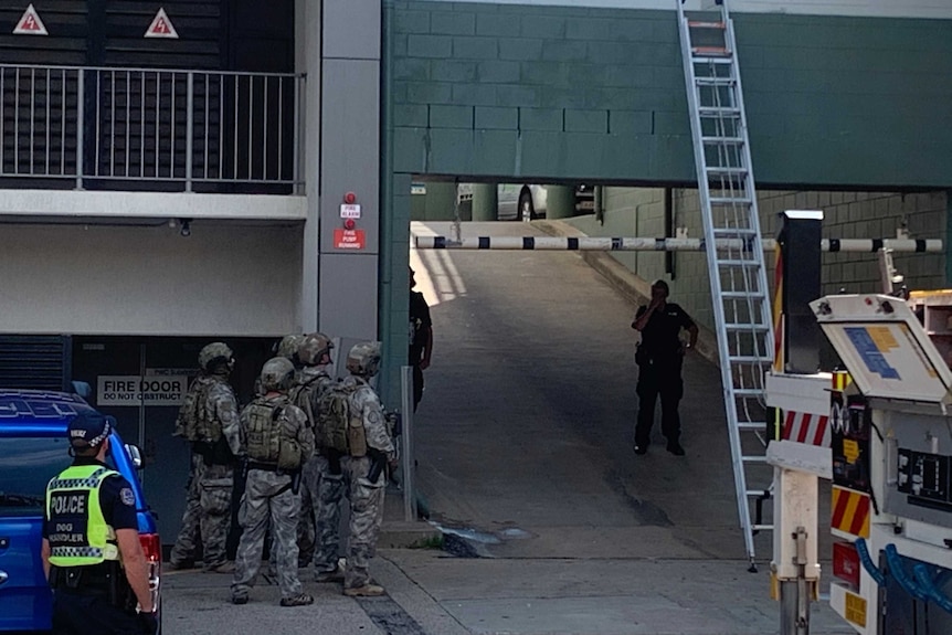 Tactical response group police officers stand outside Darwin's Luma Luma hotel during a standoff.