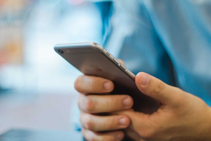 A photograph of someone's hands holding a mobile phone.