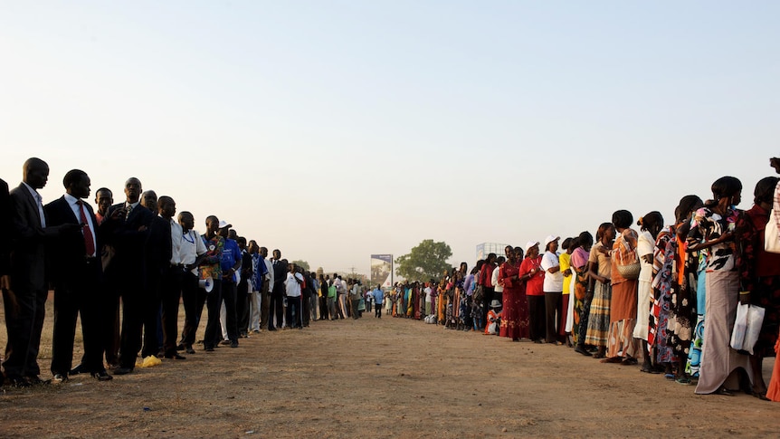 Southern Sudanese men and women line up outside a polling station (AFP: Phil Moore)