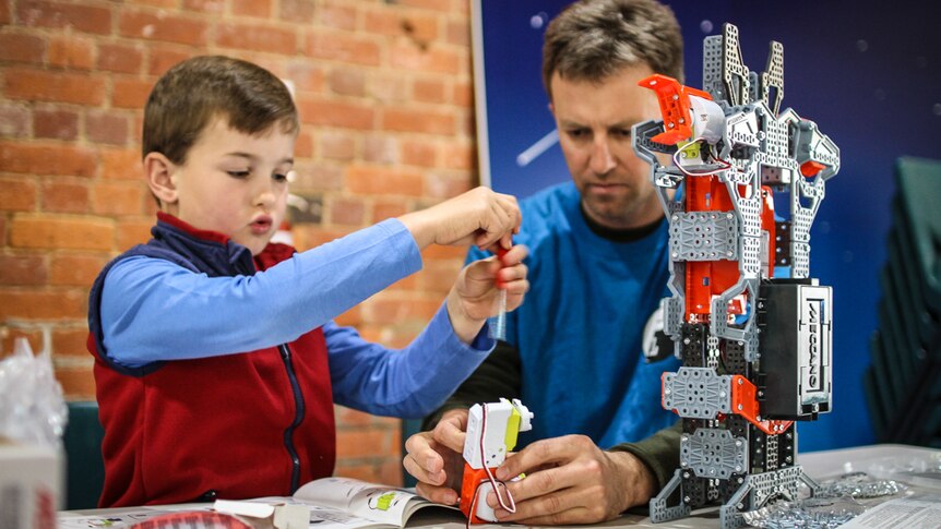 Henry, 7, with his father and mentor Julian Hall building a robot which will then be programmed to move.