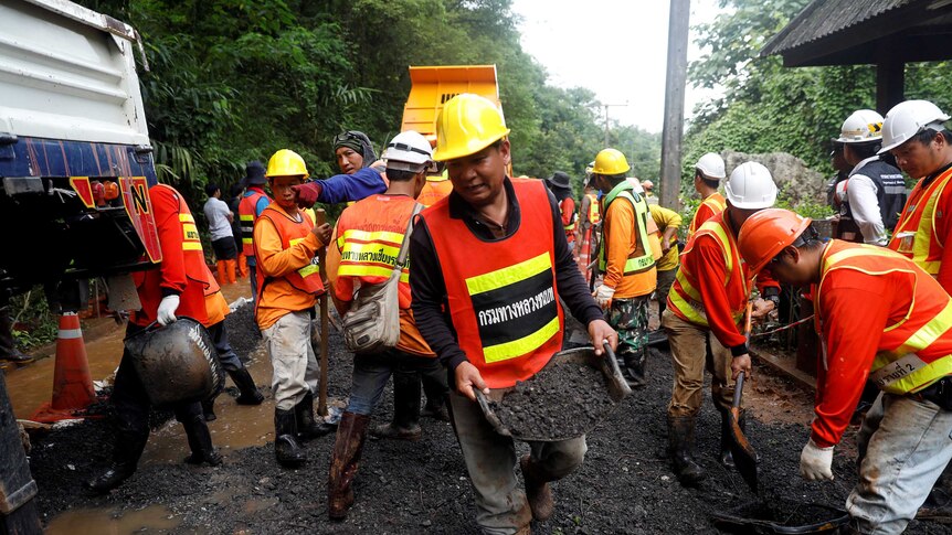 Rescue workers clear dirt near the Thai cave complex where 12 boys and their soccer coach were found 9 days after going missing