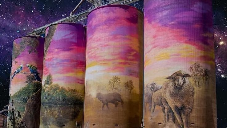 Four painted silos against the night sky 