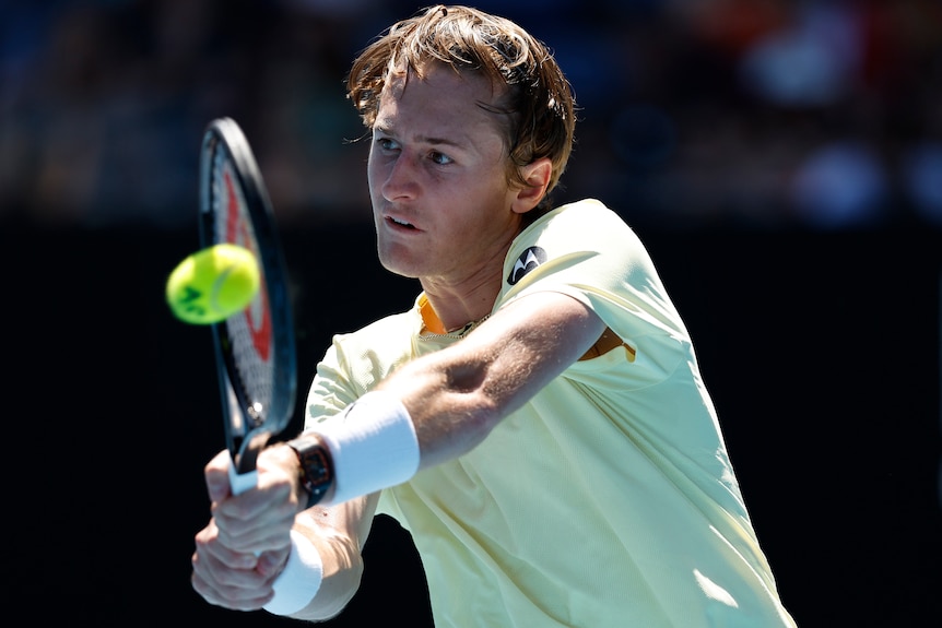 Un joueur de tennis américain frappe un revers à l'Open d'Australie.