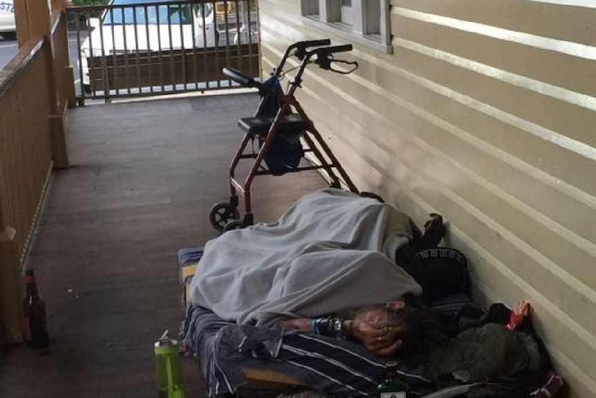 A man sleeping rough on a verandah