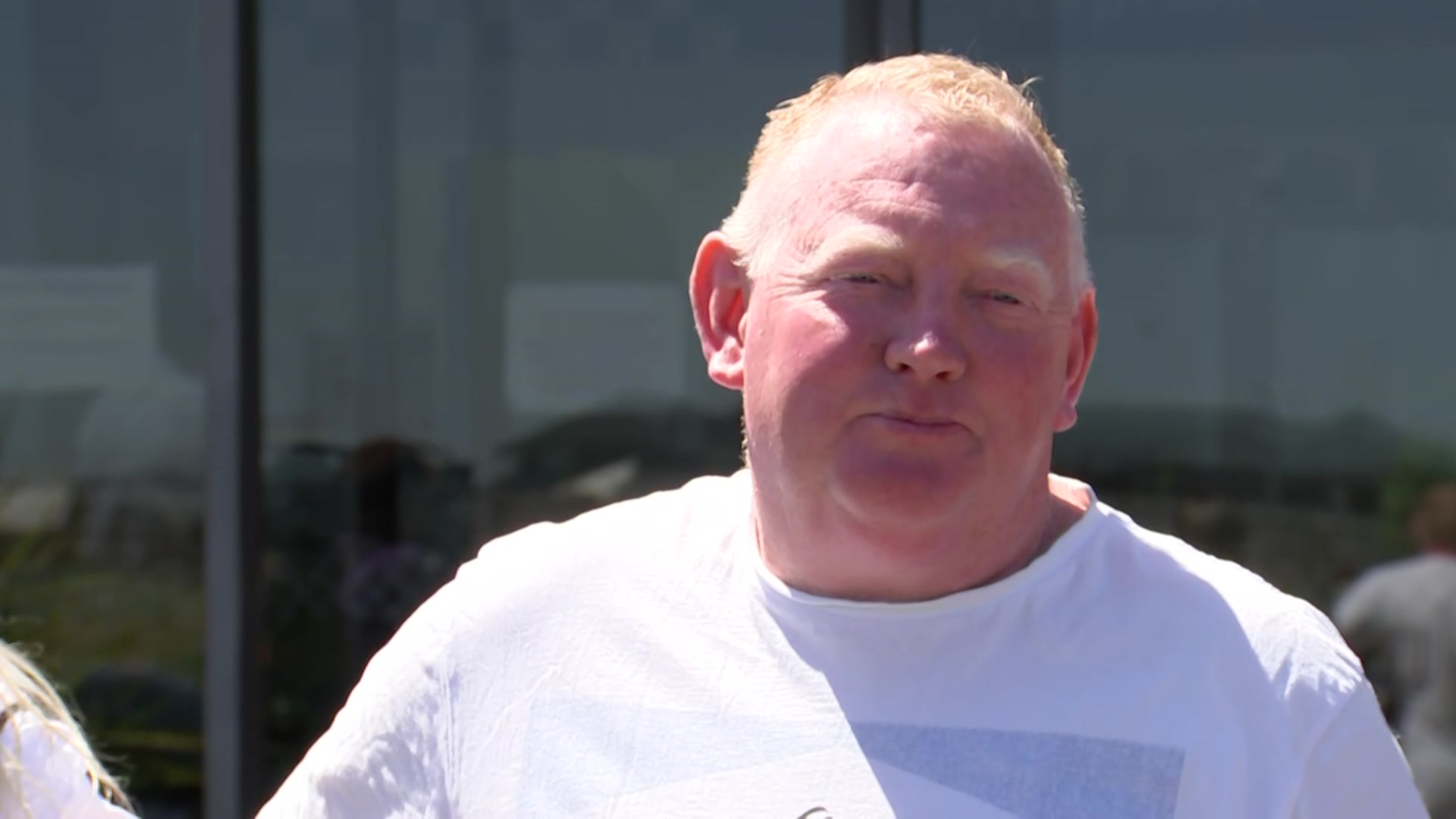 a man with bald head in a white t-shirt