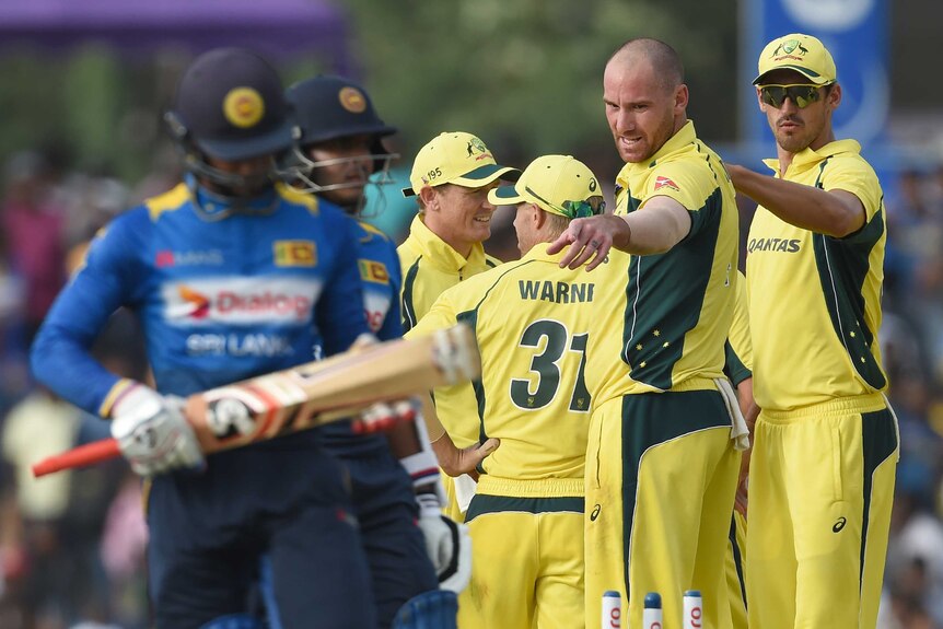 Australia's John Hastings (2R) celebrates after dismissing Sri Lanka's Dhananjaya de Silva (L).