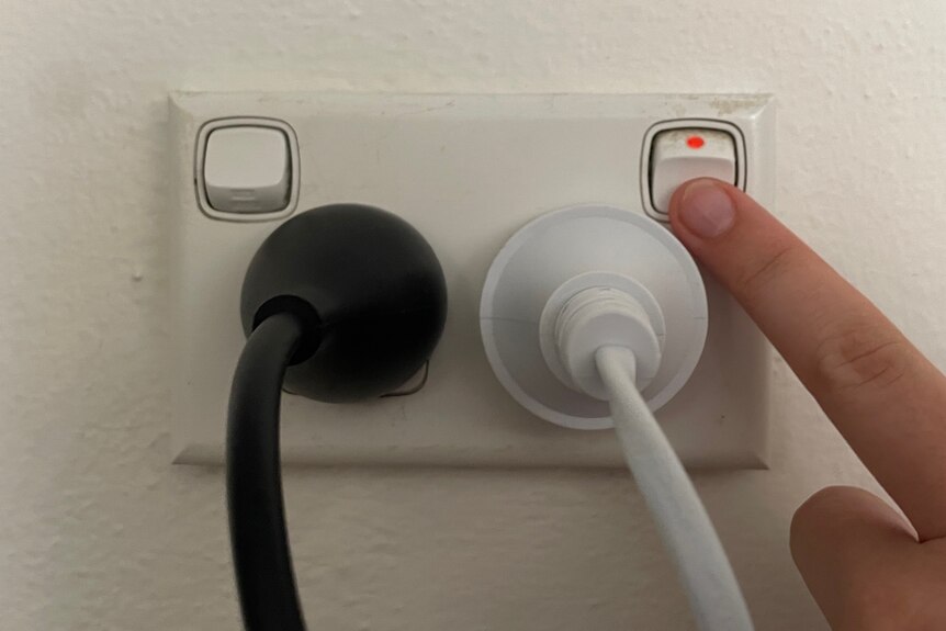 A finger hovers over a power point's off switch.