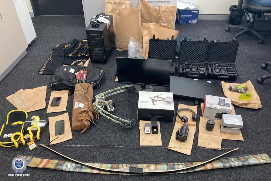 Items including electronic goods and drones laid out on a carpet floor.