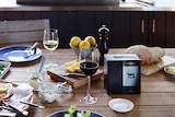 A box of wine sits among a beautifully styled dinner table laden with food