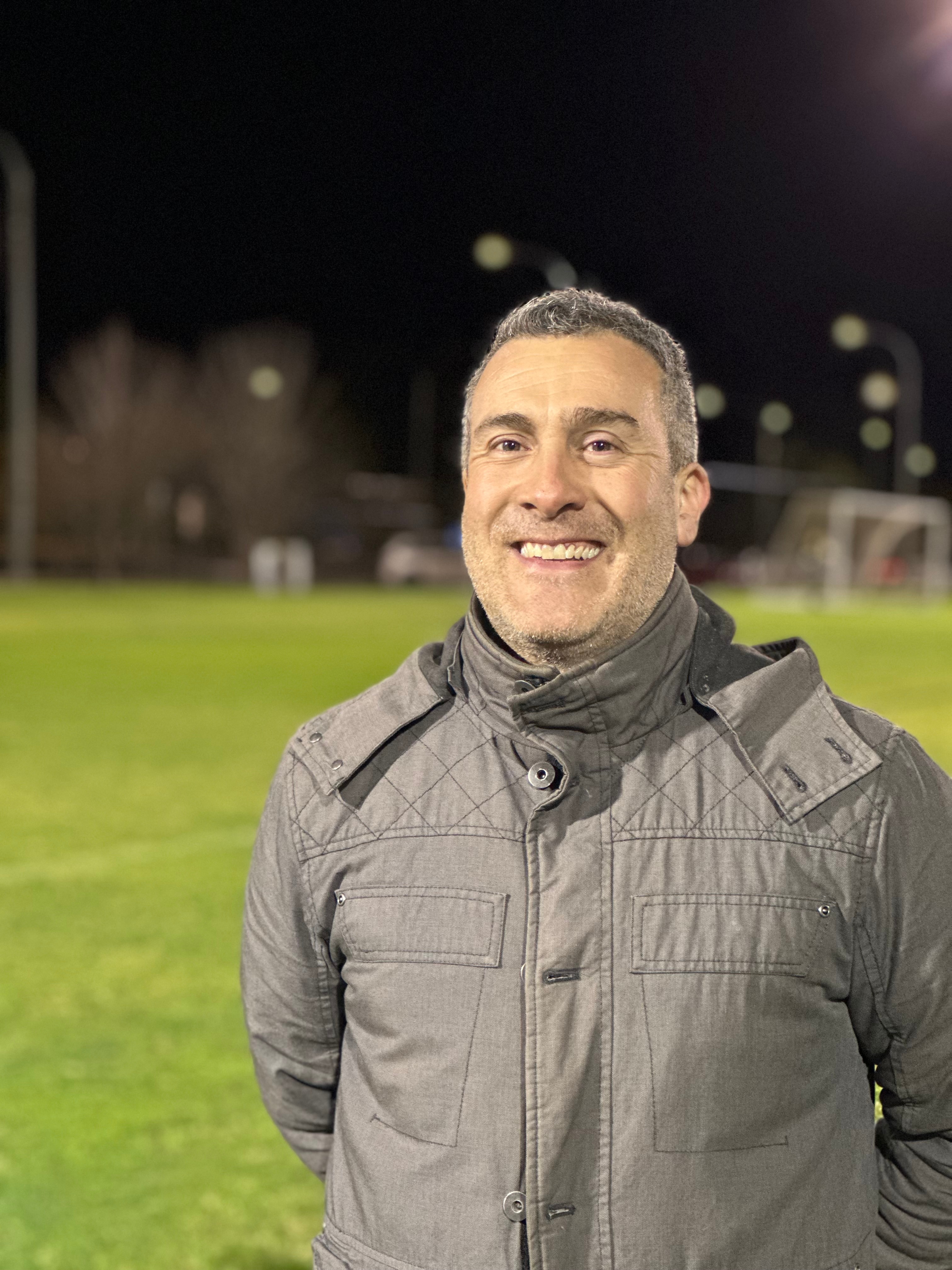 Close up image of a person wearing jacket in a soccer ground