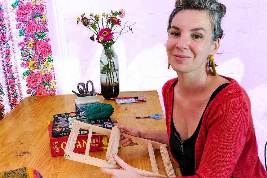 Woman sitting at table with loom pictured in story about how to control online shopping during coronavirus pandemic.