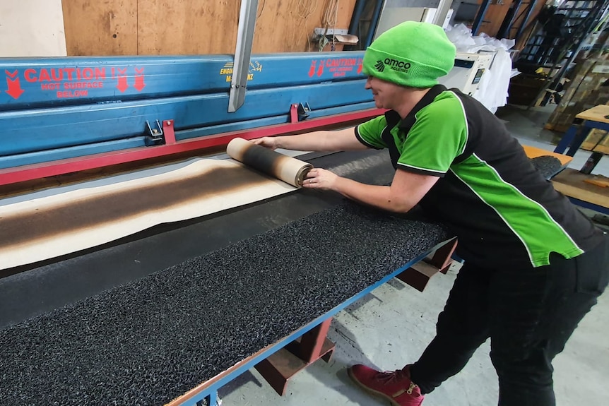 Man making a mat on a machine 