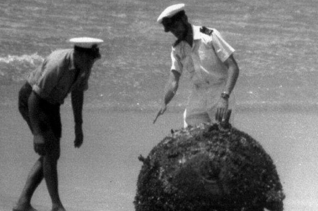 The bomb on the beach is inspected by John Dollar and Tom Parker.