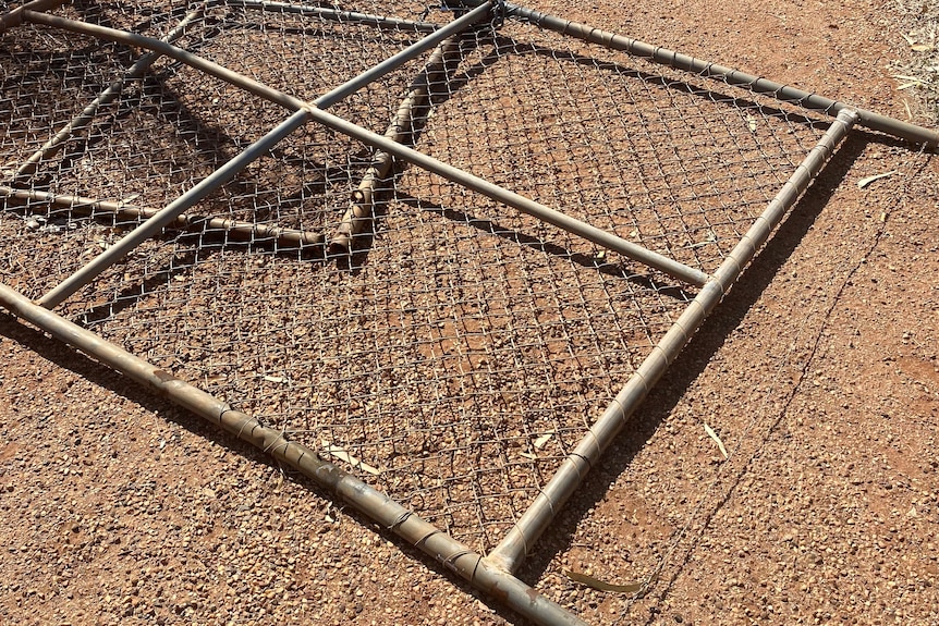 A gate lying on the ground after being pulled down 