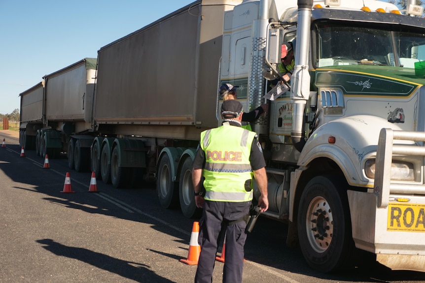 QLD police are checking the border pass of a truck from NSW