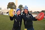 Cheezel and a player wearing blue "Rockets" beanies and holding footballs.