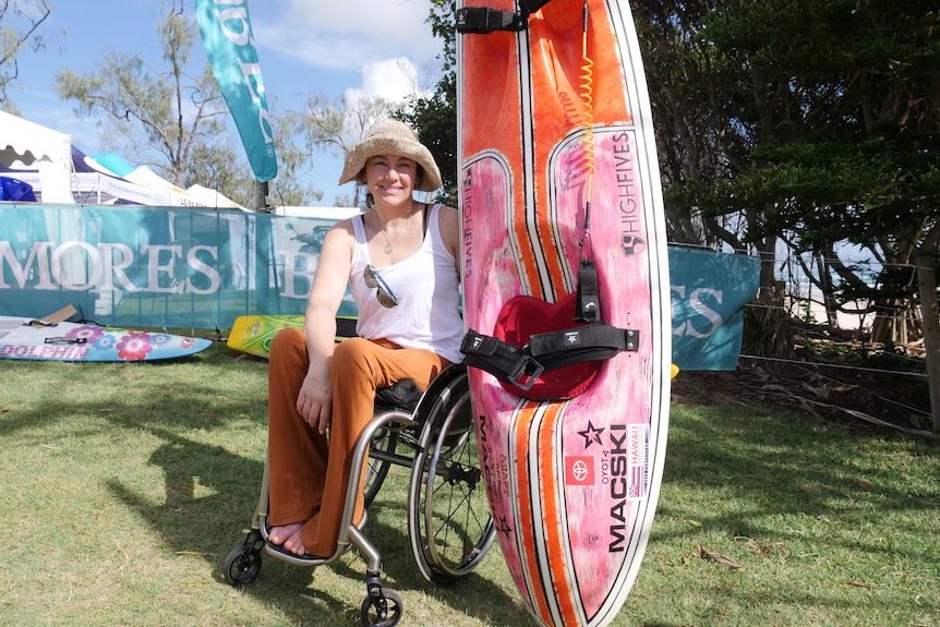 Women in a wheelchair holding a surf ski