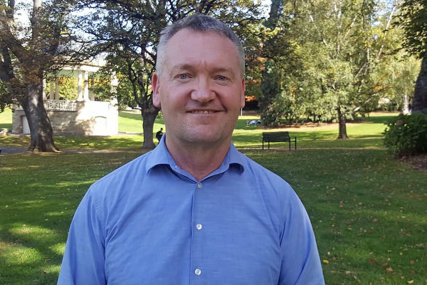 Tasmanian Anglican Reverend Jamie Bester stands in a park.