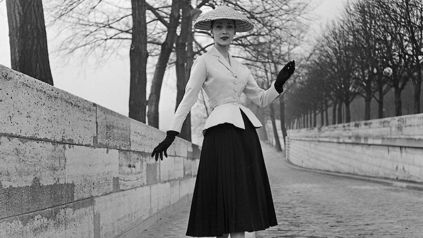 Svetlana Lloyd stands in a dress and hat in the street