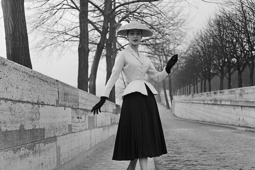 Svetlana Lloyd stands in a dress and hat in the street