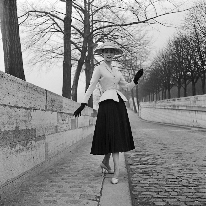 A woman models the Christian Dior 1947 Bar suit, in 1955.