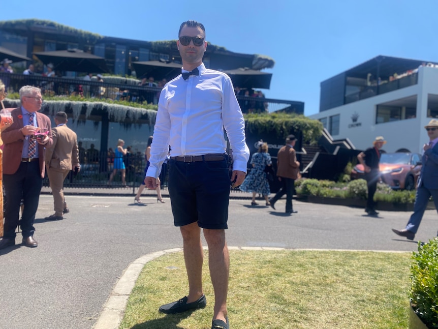 A man wearing shorts, a white shirt and a bow tie at the Flemington Racecourse.