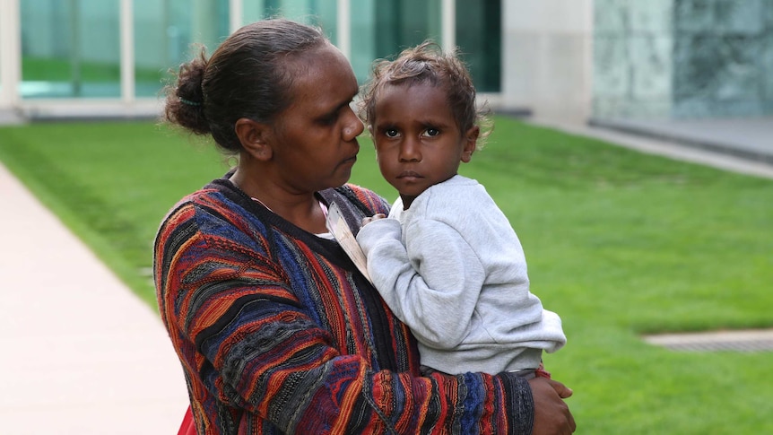 A woman holds her young son.