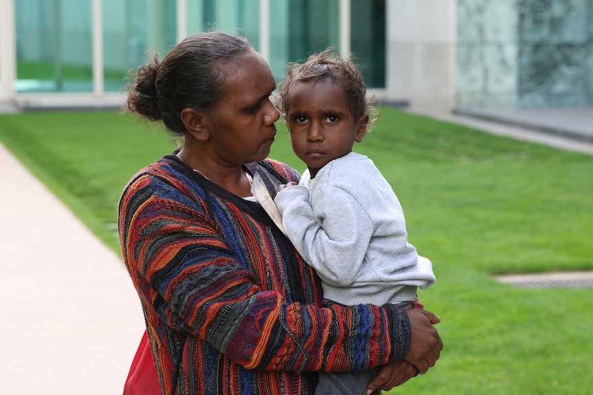 A woman holds her young son.