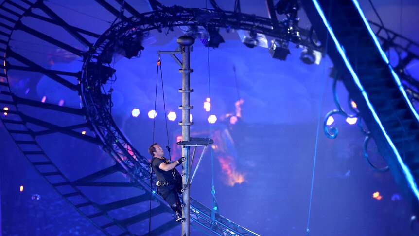 Captain Luke Sinnott climbs the flagpole to hang the Union Flag during the closing ceremony.