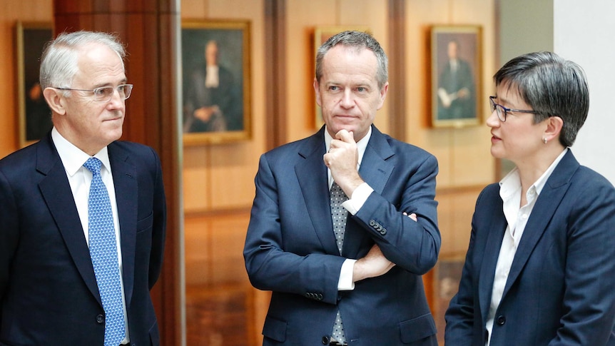 Prime Minister Malcolm Turnbull, Opposition Leader Bill Shorten and Senator Penny Wong speak in the hallway of Parliament House.