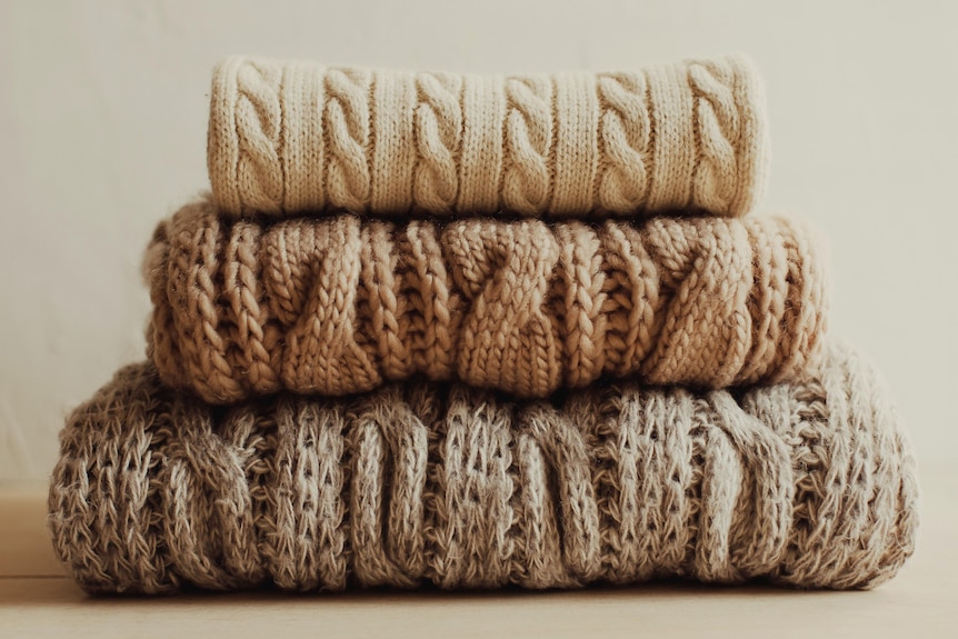 Three woollen jumpers sit atop one another