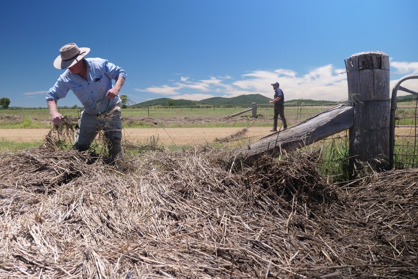 Farmer Greg Finlay is removing a fence from flood debris.