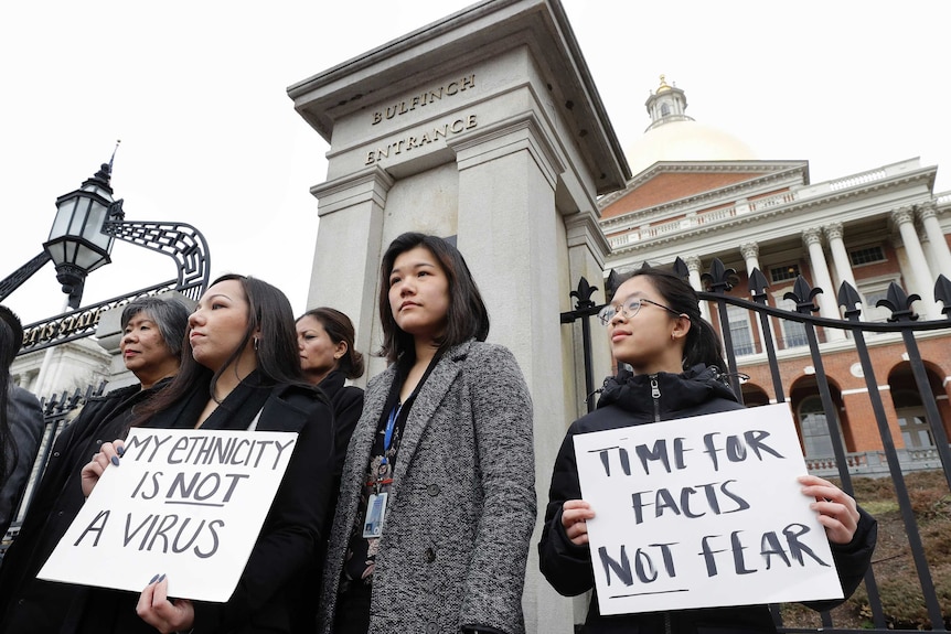 Asian American leaders protest outside a building in Boston