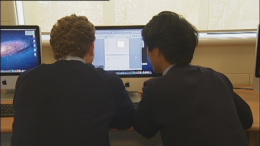 High school students using a computer to surf internet