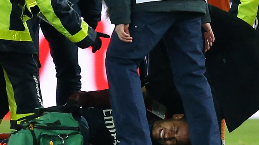 PSG's Neymar receives treatment from medical staff after being injured against Olympique Marseille.