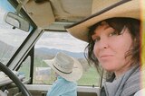  Singer Fanny Lumsden driving near her property with her child in the passenger seat, both wearing straw hats.