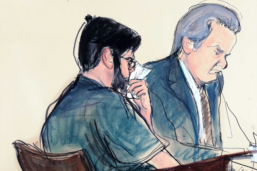 Martin Shkreli, seated next to his lawyer in court, wipes his face with a tissue.