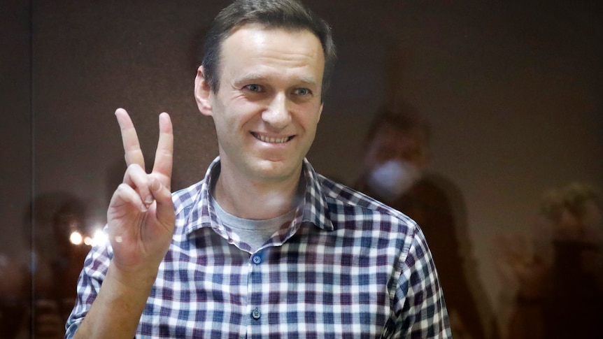Russian opposition leader Alexei Navalny gestures as he stands in a cage in the Babuskinsky District Court.